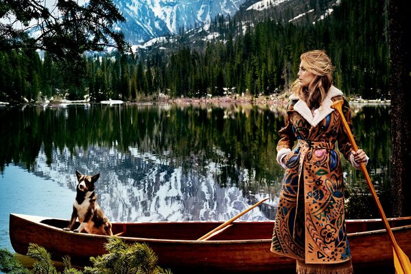 A girl with a paddle at a boat with a dog