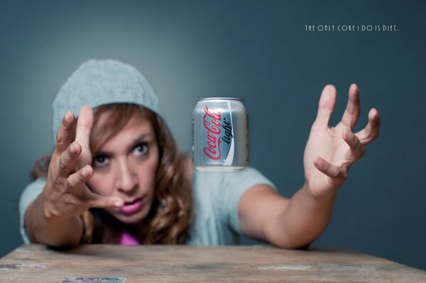 The girl catches a can of cola with her hands