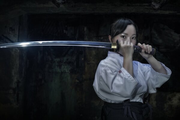 Ragazza asiatica con una spada katana in mano