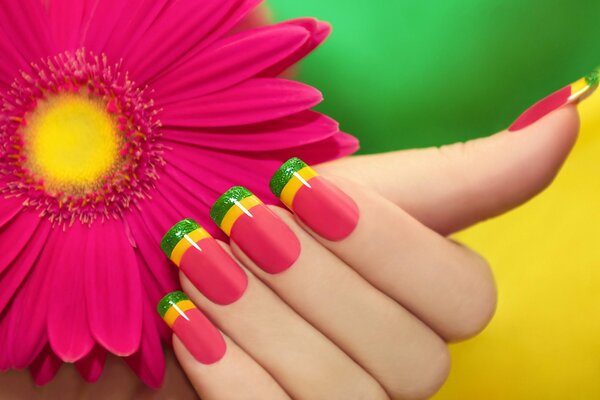 Manicura rosa con rayas de colores en el fondo de gerbera