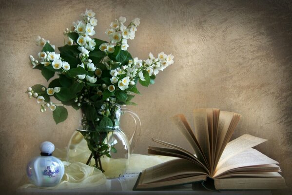 Parfüm-Buch und Jasmin in einer Vase auf dem Tisch