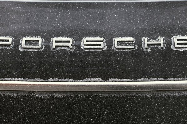 A car in snowflakes on the snow porsche