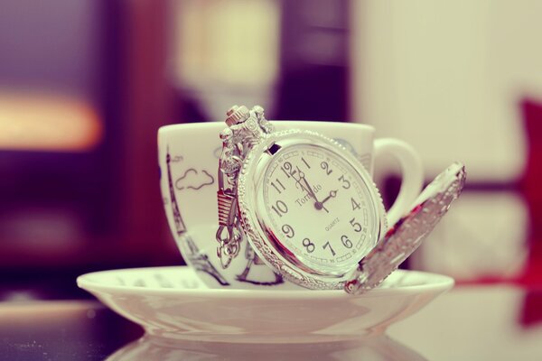 Platillo con taza y hermoso reloj