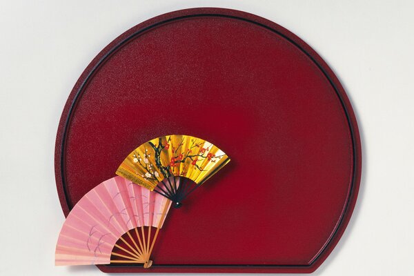 Chinese style fans on a burgundy background