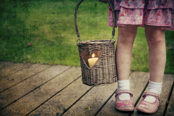 Bambina con una candela in un cestino