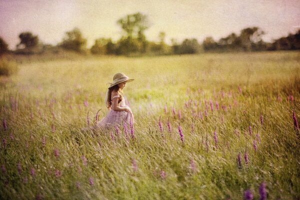 Fille au chapeau dans le champ d été