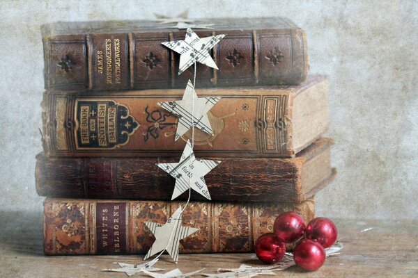 Pile de livres Vintage minables avec une guirlande d étoiles en papier et de boules rouges