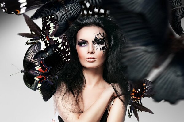 Foto de una chica con maquillaje inusual y mariposas