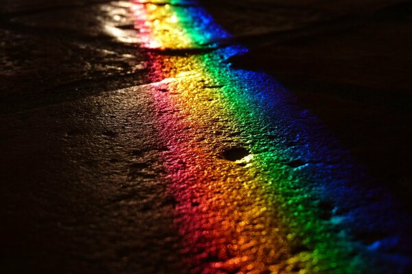 The reflection of the rainbow on the road surface at night