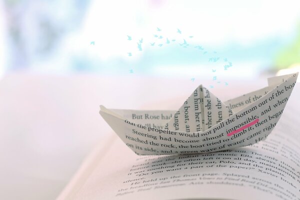 A paper ship on a book page