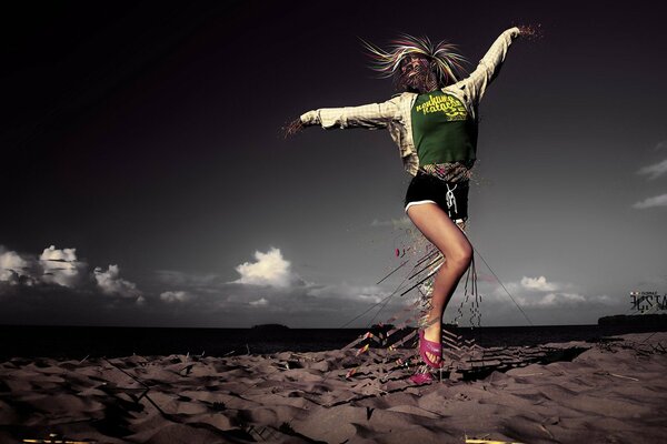 Fille sur le sable sur fond de ciel noir