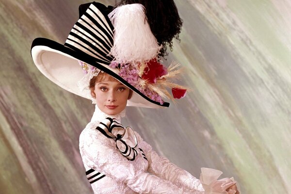 Audrey Hepburn dans des vêtements blancs et un grand chapeau