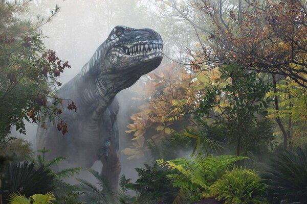 A dinosaur in a foggy gloomy autumn forest