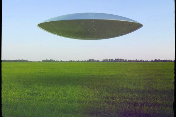 Flying saucer in the sky over the field