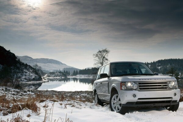 SUV sur fond de neige et lac