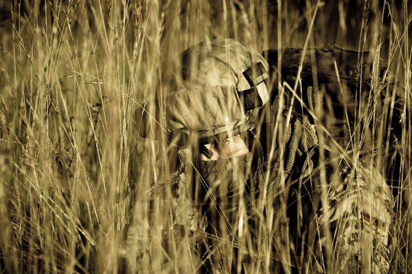 Soldado con ametralladora tendido en una emboscada en la hierba