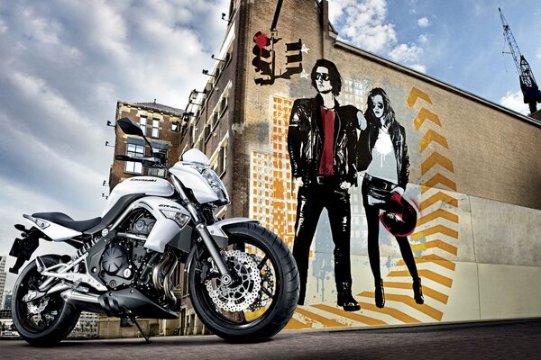 Motorcycle on the background of a guy and a girl painted on the building