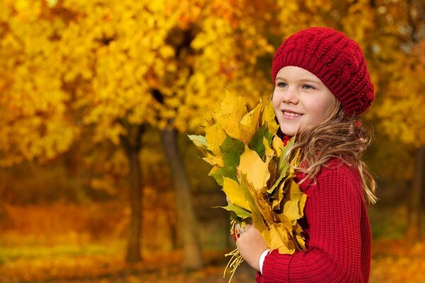 Fille avec un bouquet de feuilles d automne