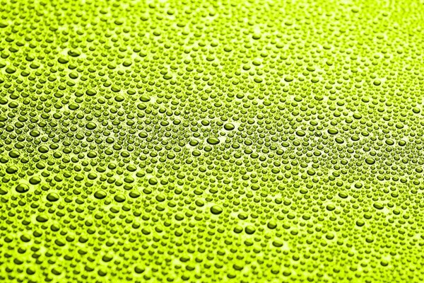 Macro disparo de gotas de agua sobre un fondo verde