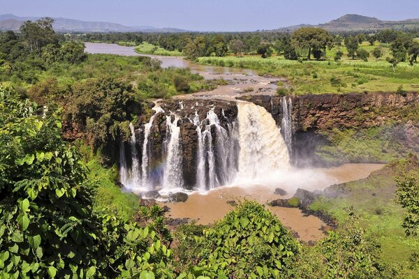 Landschaft mit Wasserfall und Wald um die Berge