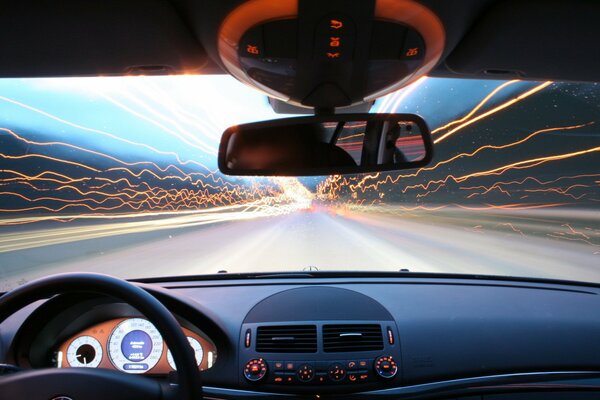 A car racing at speed. Light lines outside the windows