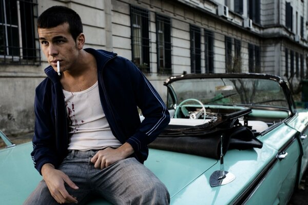 Mario Casas est assis sur le capot de la voiture