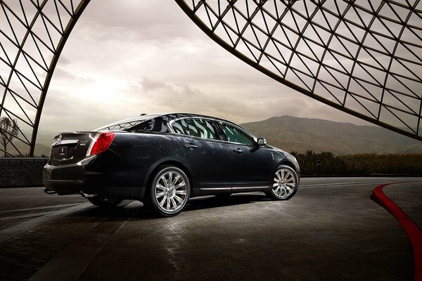 Black Chrysler on cobblestones against the background of mountains