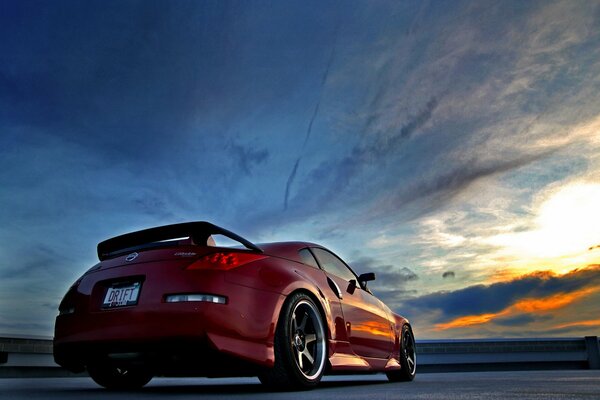 Red car on sunset background