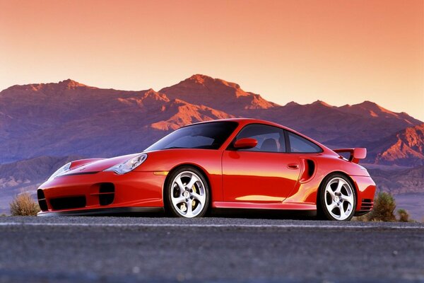 Porsche rouge sur fond de montagnes coucher de soleil