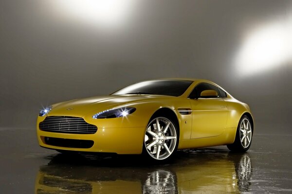 Coche amarillo aston martin v8. Reflejo de espejo en el Suelo