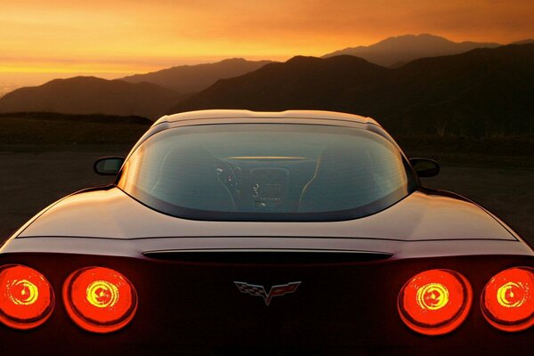 Black car rear view with headlights on