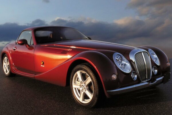 A red car is a rarity against the sky