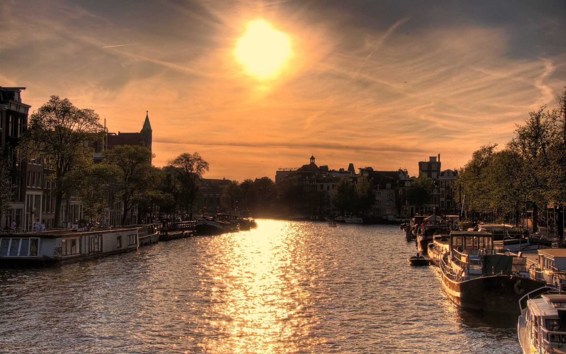 sol sobre amsterdam río sol barcos casas puesta de sol