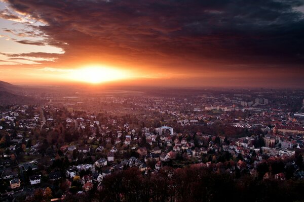 Sonniger Sonnenuntergang über der Stadt mit niedrigen Häusern