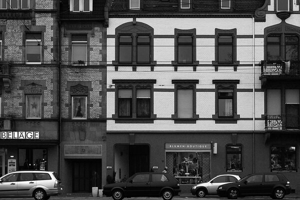 Laconic design of a house with parked cars in black and white