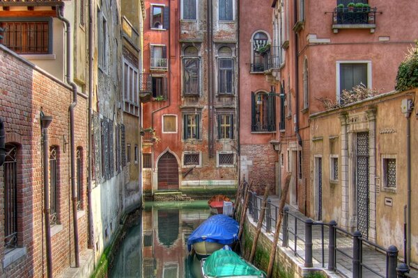 Aparcamiento de barcos cerca de casas en Venecia