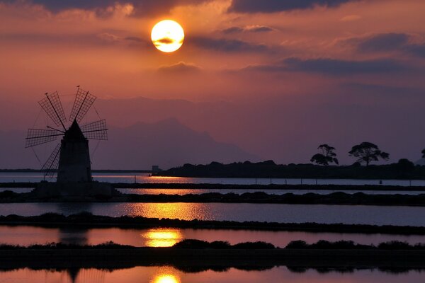 Mill on the background of the departing sun