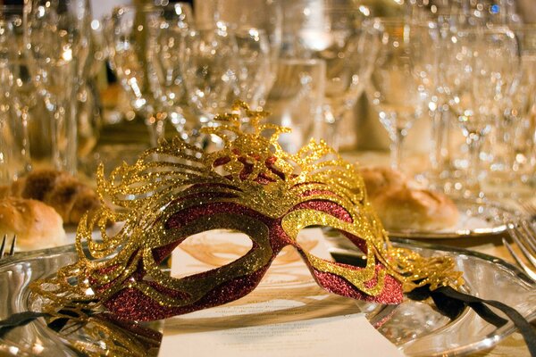 Masque de mascarade sur la table près des verres de cristal