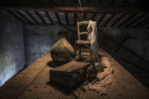 Chaise avec filet et valise dans le grenier