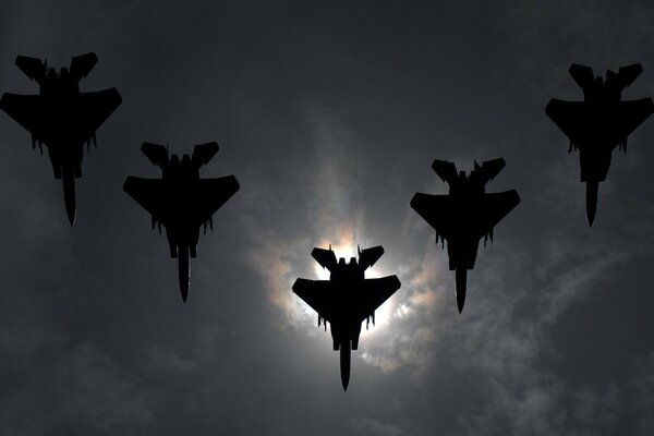 Cinq avions de chasse dans un ciel nuageux