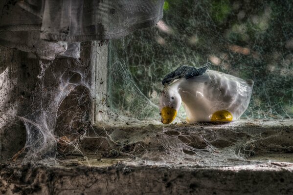 Window in a spider web with a goose figure