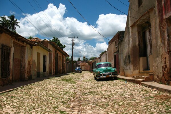 Strada con vecchie finitrici e auto retrò