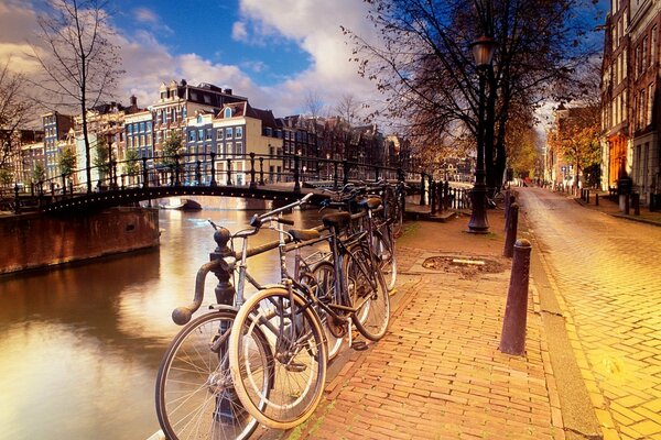 Promenada w Amsterdamie z mostem i zaparkowanymi rowerami