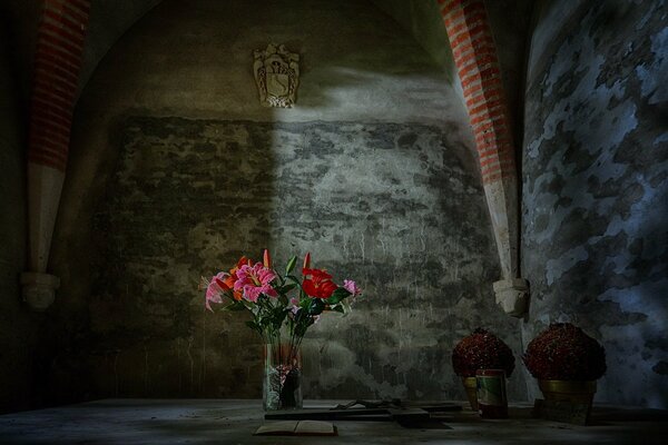 Fleurs lumineuses dans un vase dans une pièce grise