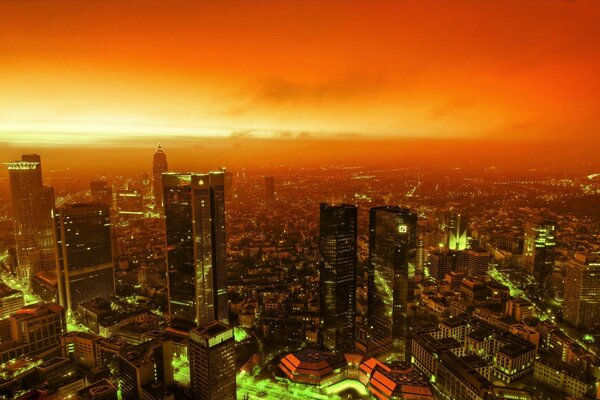 Green lights of a big city against a crimson sky