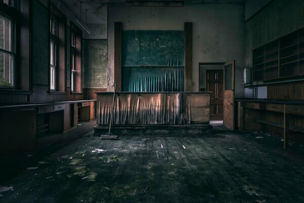 Salle de classe vide avec armoires vides, planchers et murs déchirés