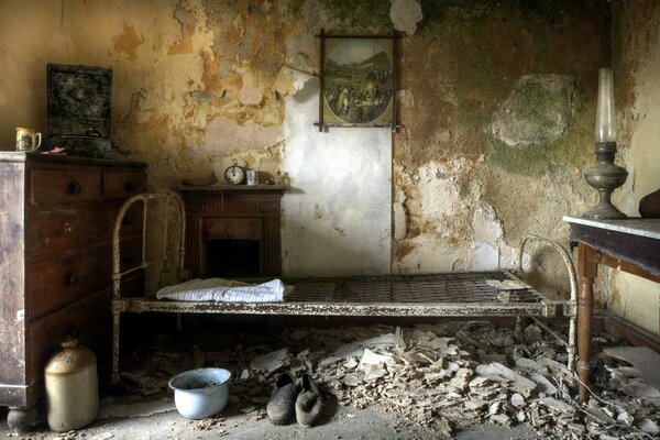 Cama contra la pared en una casa abandonada