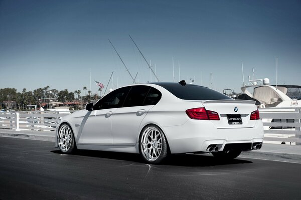 White BMW on the background of a white yacht