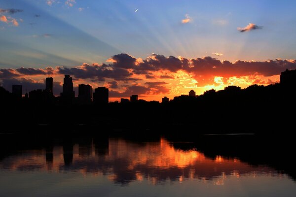 Ein schöner Sonnenuntergang über der Stadt spiegelt sich im Wasser wider