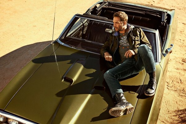 L acteur Paul Walker est assis sur une voiture pour le tournage